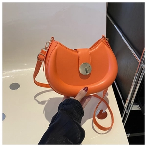 Detail of an orange crescent saddle bag with smooth PU leather and a silver metal buckle