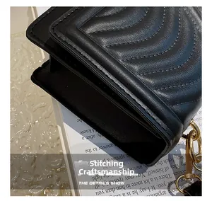 Detail of chevron stitched black leather bag with gold chain hardware and side structure