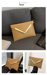 Detalle del bolso de mano tipo sobre caqui con acolchado en V y ribete dorado