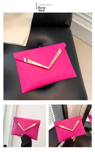Detalle de bolso sobre rosa fucsia con barra metálica en V dorada y cuero acolchado