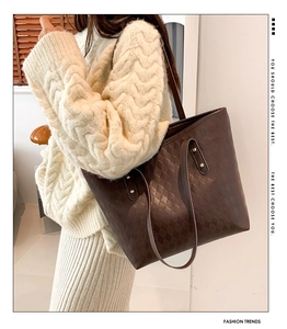 Detail of dark brown tote bag with diamond embossed pattern on knitted sweater