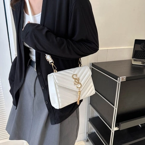White V-quilted leather crossbody bag with gold tassel, styled on female model for workwear