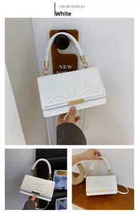 Detail showing white quilted wavy leather texture with gold hardware and woven handle