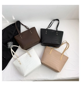 Detailed overhead view of quilted tote bags in dark brown, black, white, and khaki colors