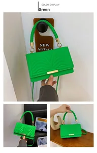 Detail of green quilted leather bag with V-shaped stitching and gold metal clasp