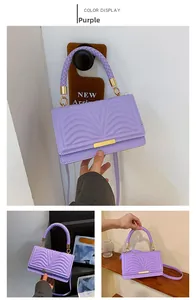 Detailed view of purple quilted handbag with gold hardware and woven handle accents