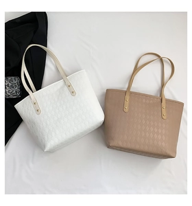 Detail of quilted tote bags in white and khaki featuring premium textured faux leather