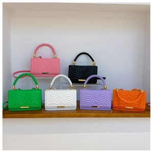 Close-up of quilted mini crossbody bags in multiple colors with gold lock and woven handle
