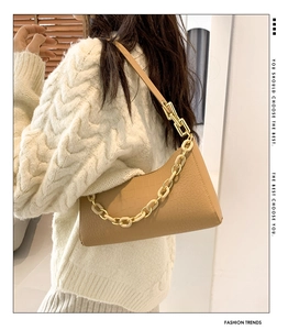 Detail of caramel crocodile pattern shoulder bag with decorative thick chain strap