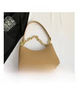 Close-up of light brown faux crocodile leather underarm bag with gold chain and strap