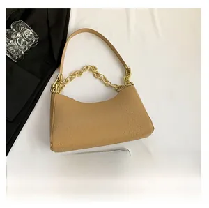 Crocodile pattern khaki underarm bag with gold chain shown next to a smartphone for scale