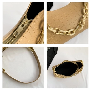 Close-up of crocodile pattern leather texture with gold zipper and stylish chain detail