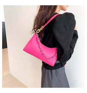 Detail of hot pink crocodile pattern shoulder bag with a chunky decorative chain