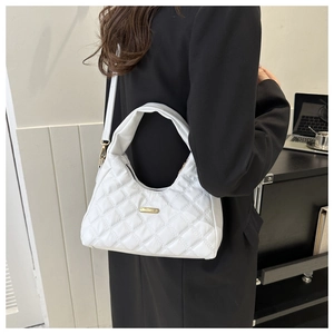 Detail of white quilted crossbody bag with golden logo plaque and elegant diamond pattern