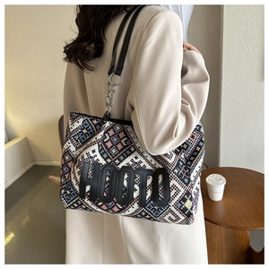 Detail of woven tote bag featuring geometric patterns and HOOTO leather patch logo