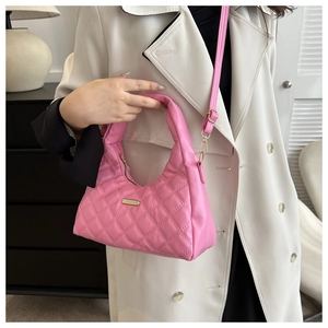 Pink quilted crescent bag with gold chain strap shown on a woman in white coat
