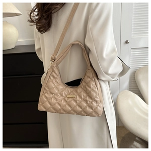 Detail view of apricot quilted hobo bag with gold metal plate and adjustable strap