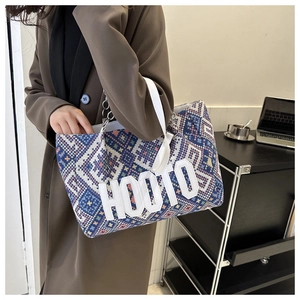Detail of vintage woven tote bag with geometric diamond patterns and HOOTO lettering