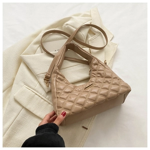 Detail of beige quilted crescent bag with gold metal plate and chic chain strap