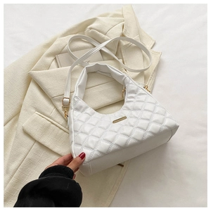 Detail of white quilted crescent bag showing golden metal bar and fine PU leather texture