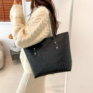 Quilted black tote bag with long shoulder straps and elegant diamond lattice texture