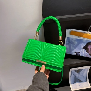 Chic green quilted crossbody bag with woven handle and gold hardware detail