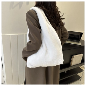 Gros plan d'un sac cabas en peluche blanche montrant la texture douce de la fausse fourrure