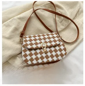 Detail of wool quilted crossbody bag with brown leather trim and vintage gold buckle