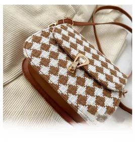 Detail view of the brown houndstooth saddle bag base with premium leather piping