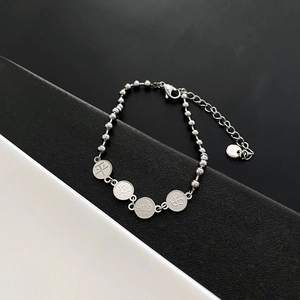Bracelet à perles en acier titane orné de quatre pendentifs porte-bonheur gravés