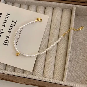 Bracelet en perles style français avec bille dorée et fermoir K18 sur plateau velours