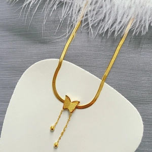 Elegante collana a farfalla dorata con catena a serpente su supporto bianco a cuore
