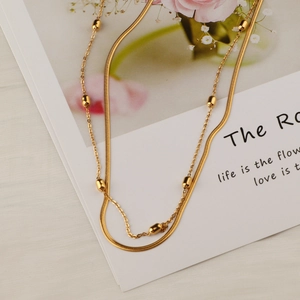 Double-layered gold titanium necklace with sleek snake chain and polished beads details