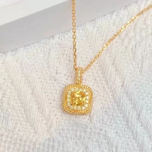 Détail macro d'un collier en or 18k avec pendentif diamant jaune carré et micro-pavage