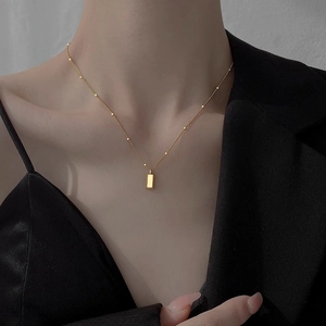 Minimalist 18K gold geometric bar necklace with bead chain on a female model