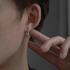 Polished silver Mobius twisted hoop earrings worn by model showing small sleek design