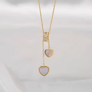 Collier à double pendentif cœur en nacre avec détails pavés de cristaux dorés