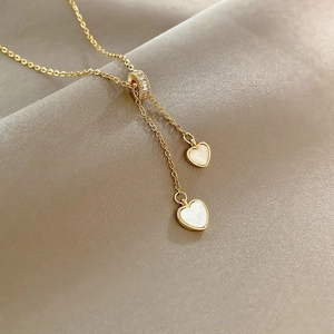 Collier en Y doré avec pendentifs double cœur en nacre et curseur réglable en zircone