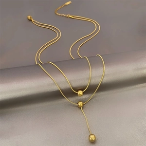 Double-layered gold titanium steel necklace featuring sleek snake chains and bead accents