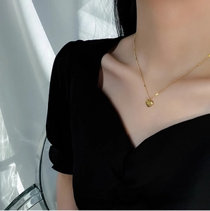 Elegant gold heart pendant necklace on minimalist chain shown on model neckline