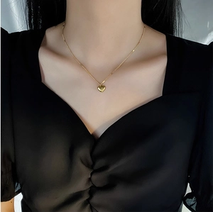 Polished gold heart pendant necklace for women worn on neck with minimalist chain