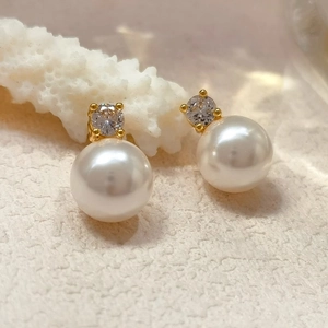 Elegant white round pearl stud earrings with gold setting and cubic zirconia accents