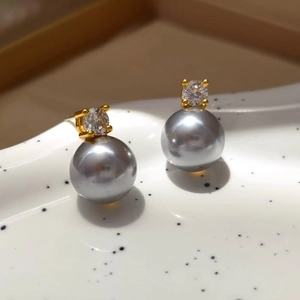 Elegant silver-grey pearl stud earrings with sparkling zirconia in a gold setting