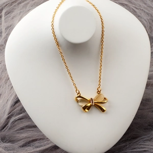 Elegante collana a fiocco dorata con pietre occhio di gatto su un manichino
