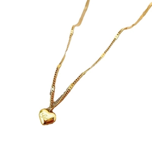 Polished gold heart necklace with Love engraving on a minimalist stainless steel chain