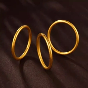Three stackable gold matte rings with smooth finish displayed on elegant silk background