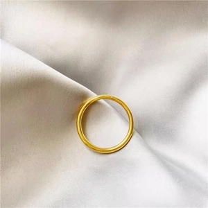 Macro detail of polished matte gold ring reflecting luxury on a soft silk background