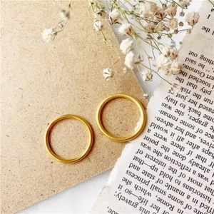Minimalist matte gold finish rings set on vintage paper with dried flowers