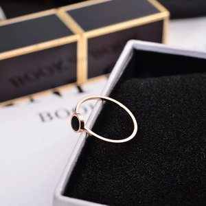 Minimalist 6mm rose gold titanium ring with round black inlay on a jewelry display box