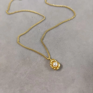 Elegant gold titanium steel necklace featuring peanut-shaped pendant and white pearl inlay